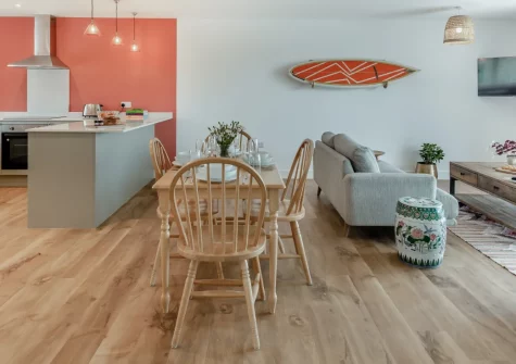 Three Corners Barn, Abbotsham is a stylish semi-detached conversion set within peaceful coastal farmland near Westward Ho!, featuring panoramic sea views from an enclosed garden, contemporary interiors, and direct access to the South West Coast Path.