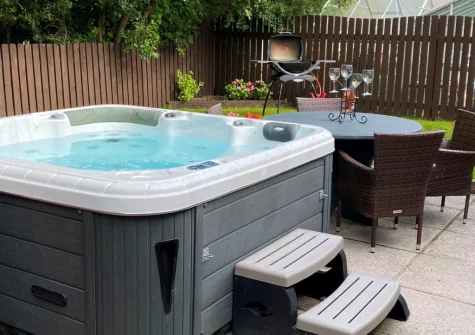 The private enclosed patio, hot tub, barbecue & alfresco dining area at Totes Cottage, Westward Ho!