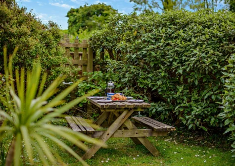 The small lawned garden, barbecue & alfresco dining area at Trailside, St Issey