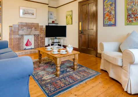 Trearth, St Merryn is a charming period cottage near Treyarnon Bay, featuring an Art Deco fireplace, peaceful countryside views, and a superb enclosed garden with glimpses toward the sea, perfectly placed for exploring Cornwall's finest beaches.