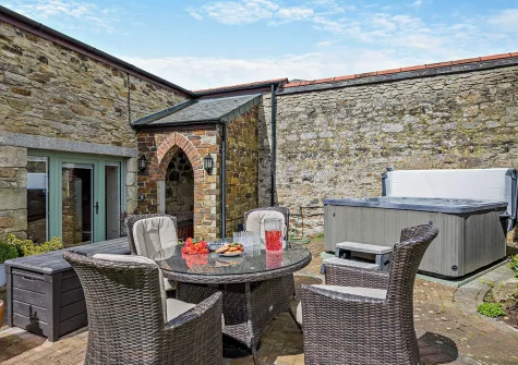 The patio, alfresco dining area & hot tub at Trebudannon Barn, Trebudannon
