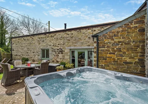 The patio, alfresco dining area & hot tub at Trebudannon Barn, Trebudannon