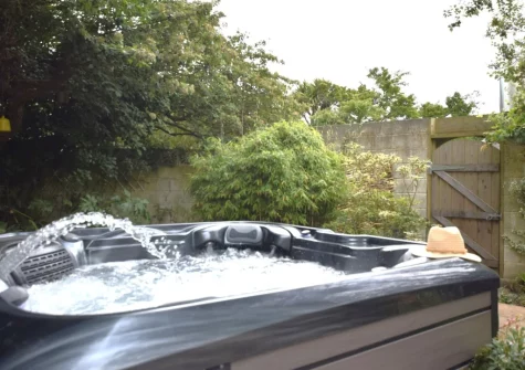 The hot tub & enclosed patio garden at Tredinnick Farmhouse, Gummows Shop