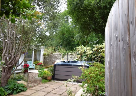 The outdoor sitting area, hot tub & enclosed patio garden at Tredinnick Farmhouse, Gummows Shop