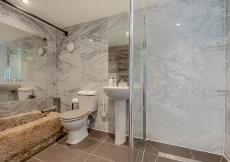 The ground floor shower room, with original feature water trough, at Tregenna Farmhouse, Tredethy