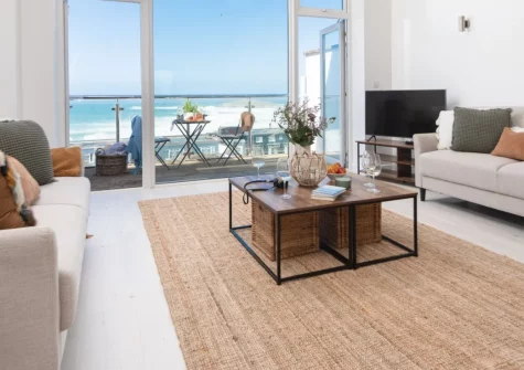 Trelantis, 5 Gwelva, Newquay is a stunning four-storey townhouse positioned above Fistral Beach, featuring spectacular ocean views from multiple private balconies, contemporary interiors, and a large garage perfect for storing surf equipment.