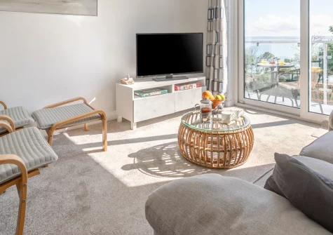 Trenance, Carbis Bay is a romantic first-floor apartment with a private balcony boasting sweeping views across St Ives Bay to Godrevy Lighthouse, a footpath to the beach, and easy access to St Ives' galleries, harbour and artistic charm.