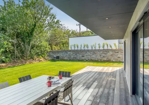 The decked terrace, alfresco dining area & garden at Treth House, Widemouth Bay