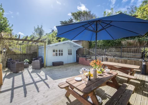 The decked patio, alfresco dining, sitting area & summer house at Trevethen Cottage, Crantock