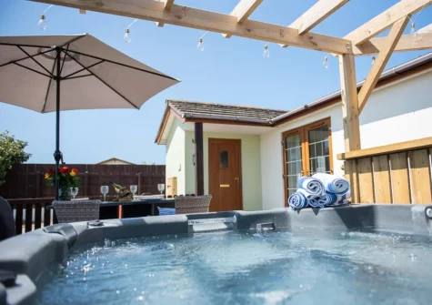 The patio, alfresco dining area & hot tub at Twinkle Cottage, Westward Ho!