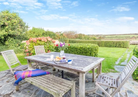 The patio, alfresco dining area & enclosed lawned garden at Two Stiles, St Merryn