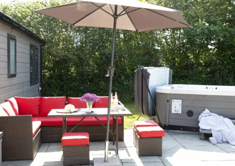 The patio, alfresco dining area & hot tub at Violet Lodge, 11 Roadford Lake Lodges, Broadwoodwidger
