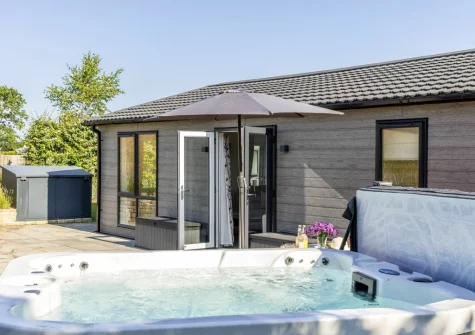 The patio & hot tub at Violet Lodge, 11 Roadford Lake Lodges, Broadwoodwidger