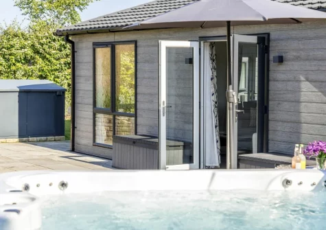 The patio & hot tub at Violet Lodge, 11 Roadford Lake Lodges, Broadwoodwidger