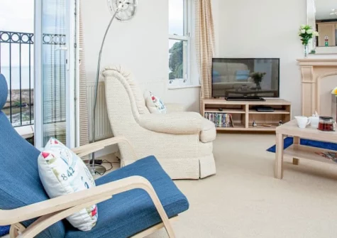 Waves at Great Cliff, Dawlish is a spacious two-bedroom third-floor apartment with spectacular bay views towards Exmouth, just a minute's level walk from the town centre, featuring modern interiors, private parking, and direct access to the beach.