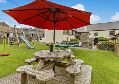 The garden, alfresco dining area & children's play facilities at West Goldsworthy Farm, Horns Cross