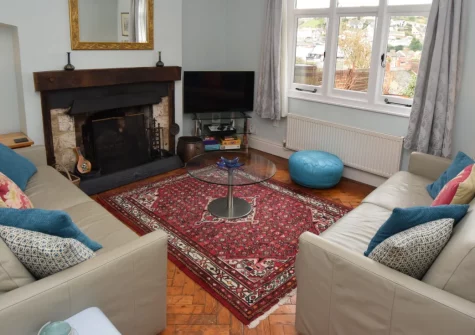 West View Cottage, Beer is a characterful Arts and Crafts property just 500 metres from the beach, featuring elegant period details, an open fire, panoramic village views from upper bedrooms, and a sunny patio with firepit overlooking Beer.