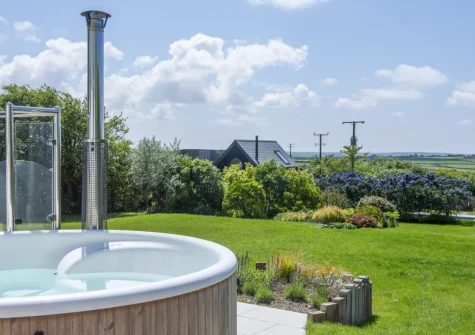 The patio, wood-fired hot tub & lawned garden at Westaway House, Trelights