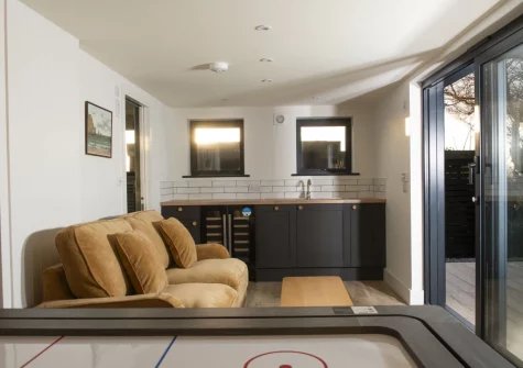 The poolhouse, with woodbuning stove, games table & sitting area at Westaway House, Trelights