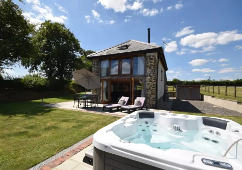 The patio, barbecue, alfresco dining area, hot tub & enclosed garden at Weston Farm Barn, East Knowstone