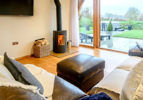 Weston Farm Barn, East Knowstone is a luxurious detached barn conversion on the edge of Exmoor, featuring a private hot tub with countryside views, spectacular vaulted bedroom, wood burner, and peaceful rural setting perfect for romantic escapes.