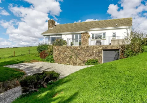Relax on the terrace with far-reaching views across the countryside toward the sea when you stay at Whitestone Farm, Lee