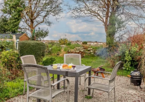 The rear garden patio, barbecue & alfresco dining area at Wild Rose Cottage, Illogan