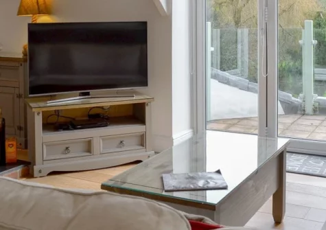 Willow Barn, Polmassick is a beautifully presented cottage nestled in peaceful Cornish countryside, featuring a bright first-floor living space with balcony, cosy woodburner, generous lawned garden with firepit, and easy access to beaches & gardens.