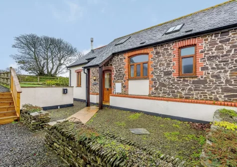 Windbury Barn's exposed stone walls, vaulted ceilings, wooden beams & a wood burner all add to this cosy cottage