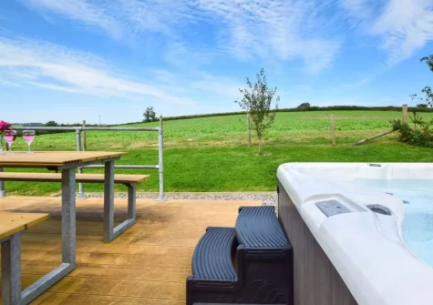 The decked patio, alfresco dining area & hot tub at Windwhistle Lodge, South Molton