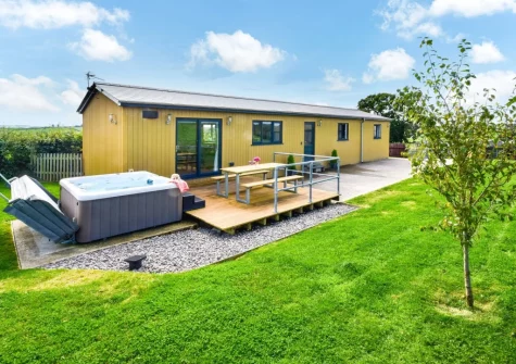 The decked patio, alfresco dining area, hot tub & garden at Windwhistle Lodge, South Molton