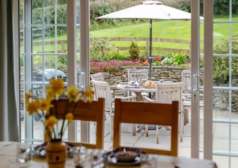 The patio, alfresco dining area & garden at Withymore Cottage, Malborough