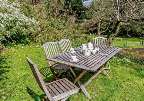 The garden & alfresco dining area at Woodcutters Cottage at Greatrock Farm, Hennock