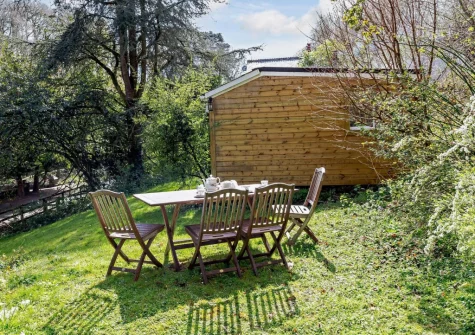 The garden & alfresco dining area at Woodcutters Cottage at Greatrock Farm, Hennock