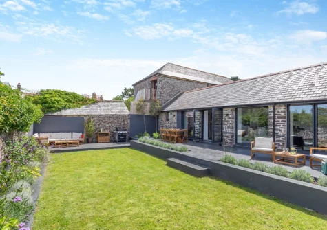 The enclosed courtyard garden with patio, alfresco dining & outdoor sitting area at Woodside Barn, Hartland