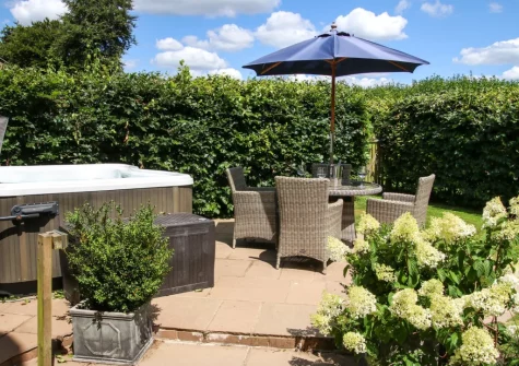 The patio, alfresco dining area & hot tub at Wrens Thatch, Ebberley