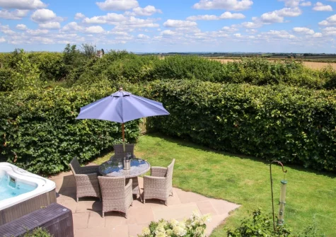 The patio, alfresco dining area, hot tub & enclosed garden at Wrens Thatch, Ebberley