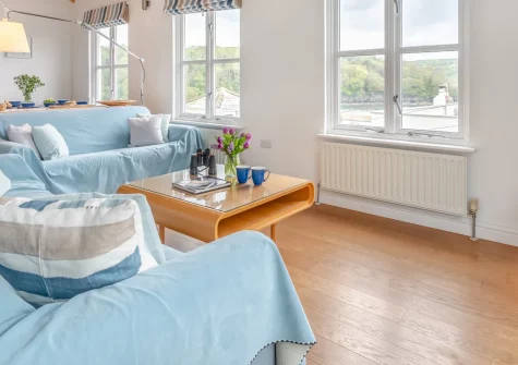 Yardarm Cottage, Fowey is a striking contemporary holiday home in the heart of this historic harbour town, featuring magnificent river and harbour views, spacious vaulted living areas, and a rare lawned garden perfect for alfresco dining.
